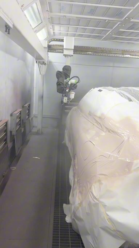 The NST robot spraying a whole car in a beige coat
